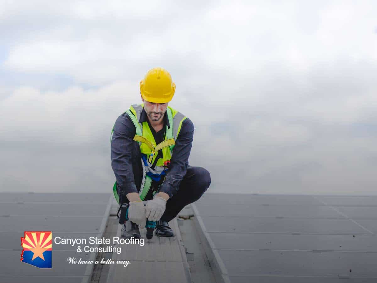 A roofer working on a solar panel installation as part of a re-roof project