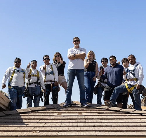 Jim McLain And Team Standing On A Roof